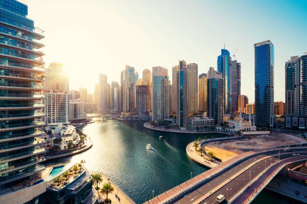 A sunrise view of modern high-rise buildings along a serene waterfront in an upscale urban neighbourhood.